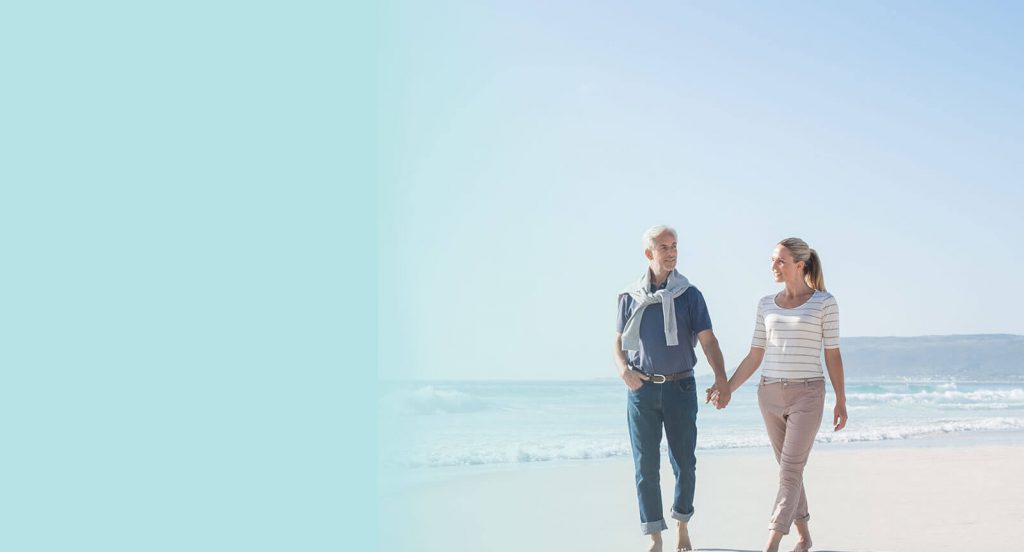A couple walking down the beach hand in hand