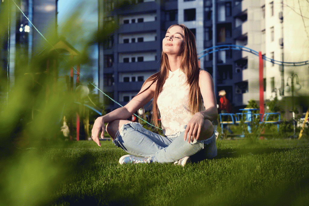 a peron sitting on the grass with the sun shining