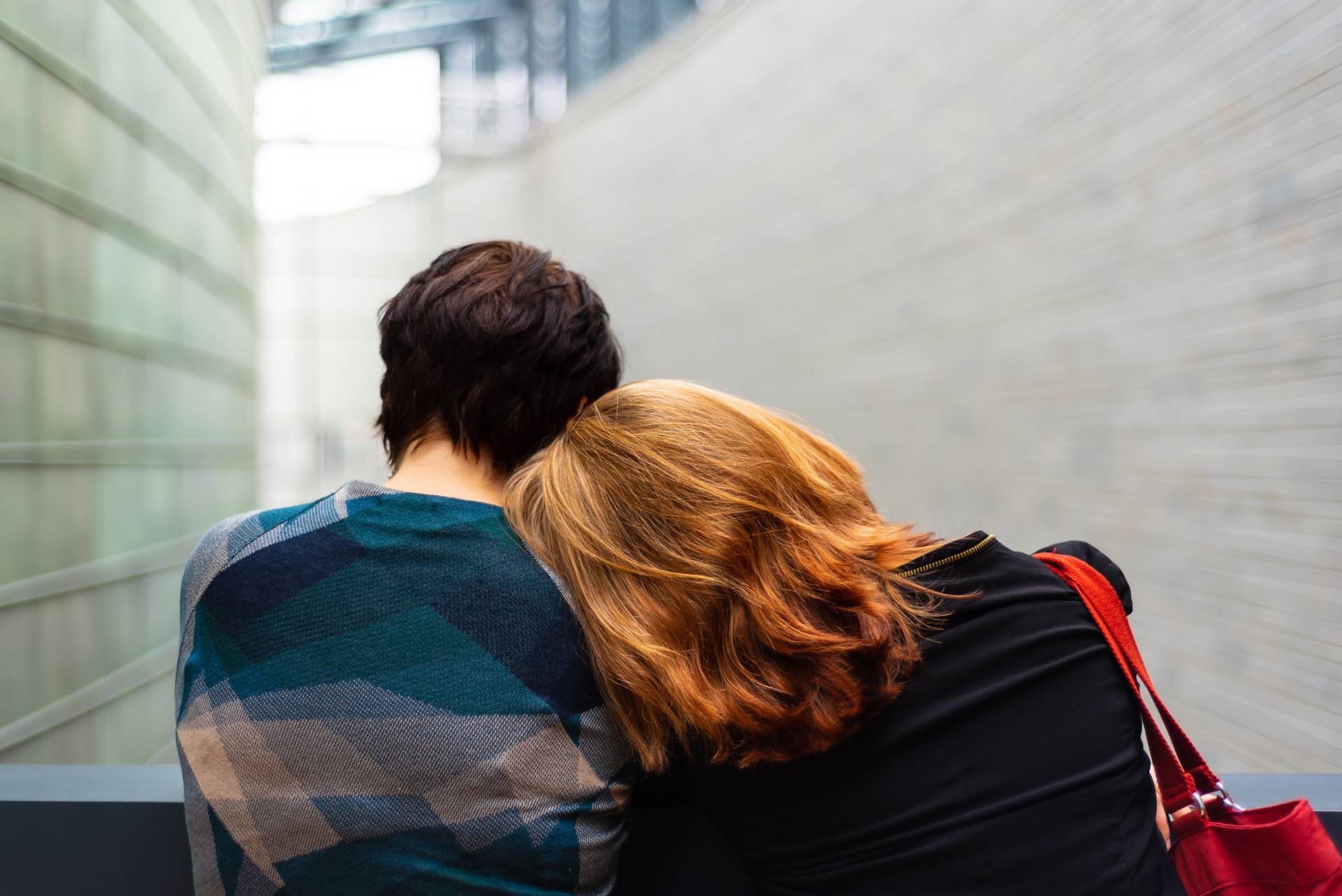 a couple with one person putting their head on the others shoulders